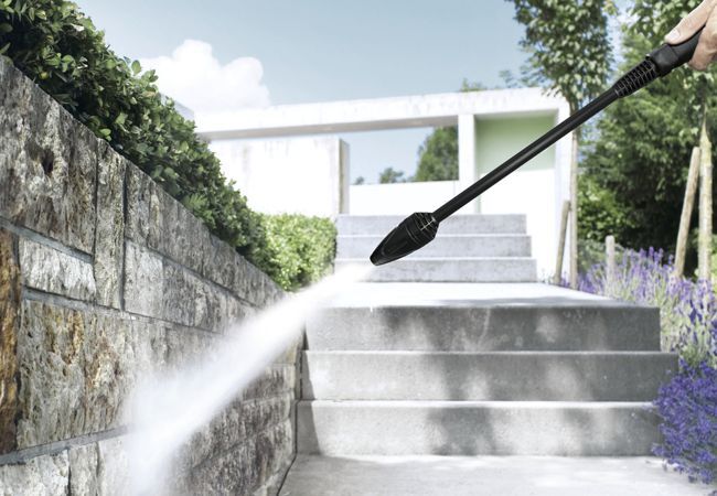 Gartenmauer wird mit einem Hochdruckstrahl gereinigt