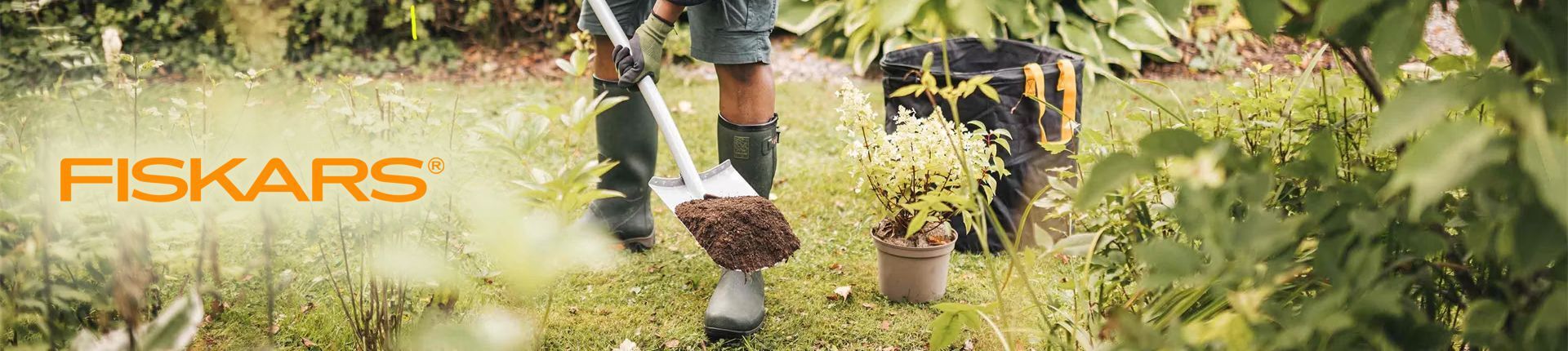 Mann bei Gartenarbeiten mit einem Fiskars Spaten Mann bei Gartenarbeiten mit einem Fiskars Spaten