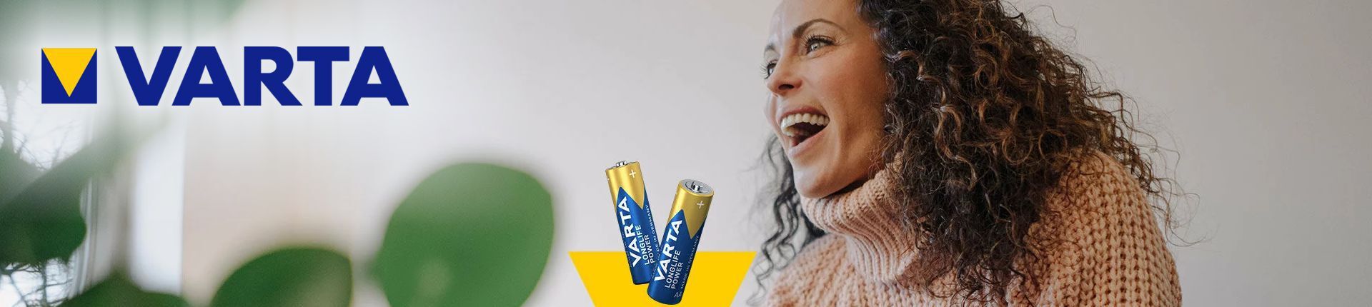 Zwei Varta Consumer Batterien neben einer jungen lachenden Frau mit brauen langen lockigen Haaren Zwei Varta Consumer Batterien neben einer jungen lachenden Frau mit brauen langen lockigen Haaren