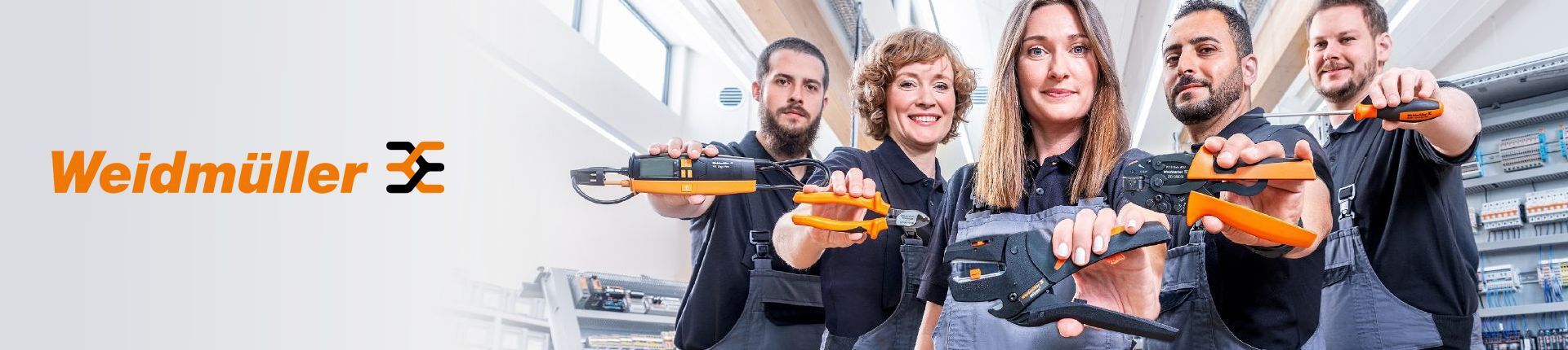 Fünf junge Menschen in grauer Arbeitskleidung halten je ein Weidmüller Werkzeug in der Hand Fünf junge Menschen in grauer Arbeitskleidung halten je ein Weidmüller Werkzeug in der Hand