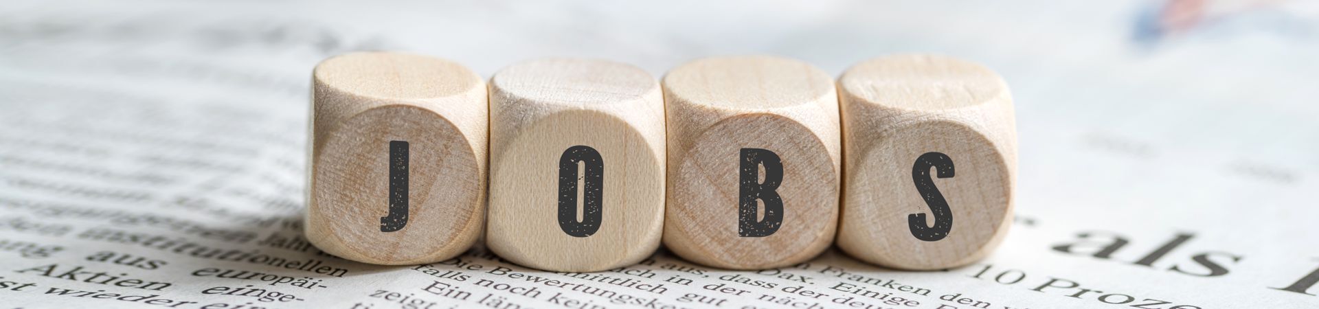 Würfel mit Aufschrift Jobs auf einer Tageszeitung Würfel mit Aufschrift Jobs auf einer Tageszeitung