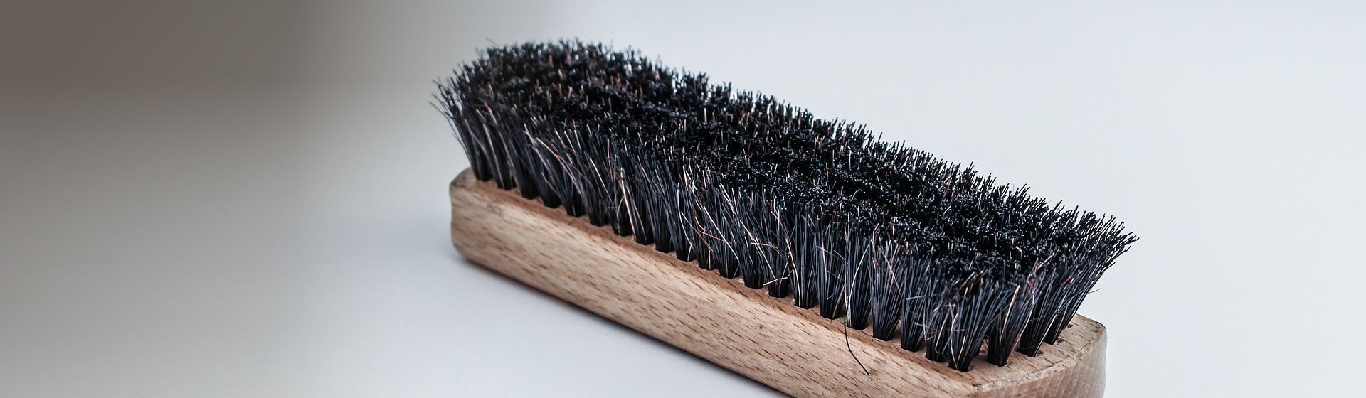 Schwarze Schuhbürste auf grauem Hintergrund Schwarze Schuhbürste auf grauem Hintergrund