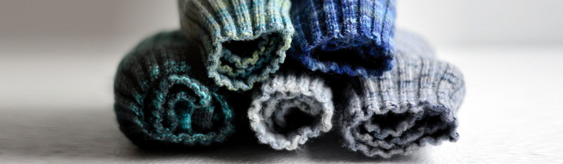 Gefaltete graune und dunkelblaue Wollsocken in Nahaufnahme Gefaltete graune und dunkelblaue Wollsocken in Nahaufnahme