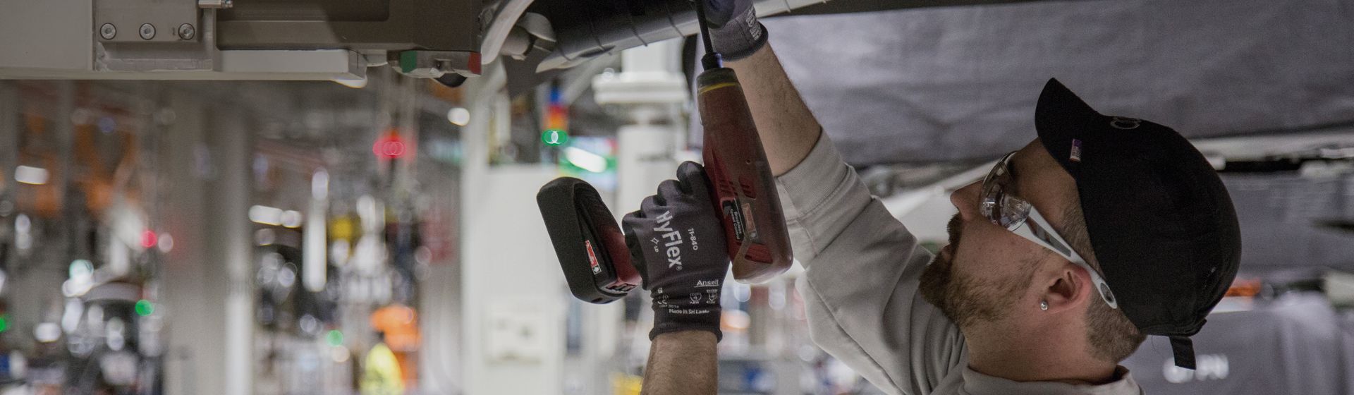 Handwerker mit Griphandschuhen von Ansell bei Arbeiten mit einem Akkuschrauber
