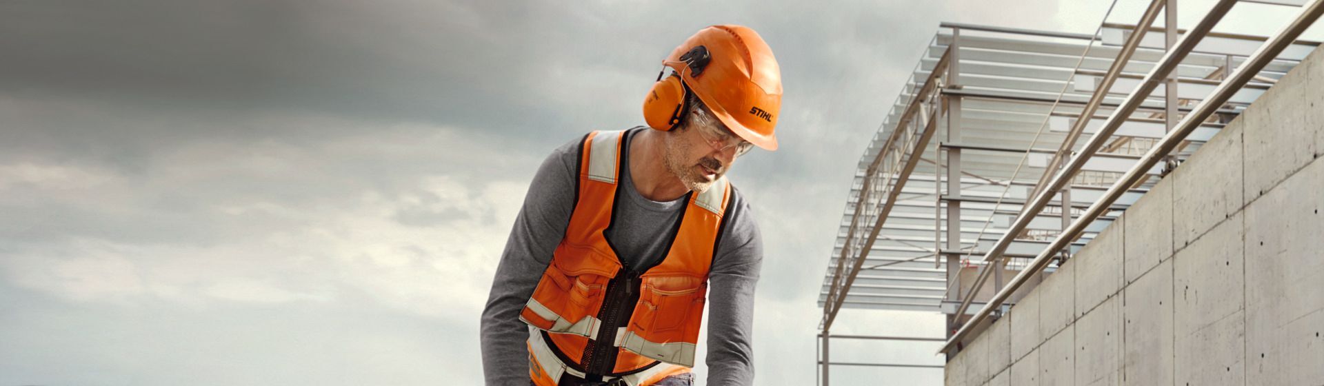 Bauarbeiter mit Stihl Schutzhelm mit Gehörschutzkapseln Bauarbeiter mit Stihl Schutzhelm mit Gehörschutzkapseln