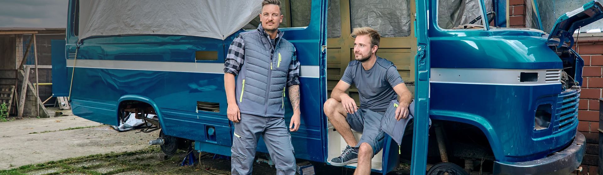 Handwerker in grauer Arbeitskleidung mit grauer Stepp-Arbeitsweste Handwerker in grauer Arbeitskleidung mit grauer Stepp-Arbeitsweste