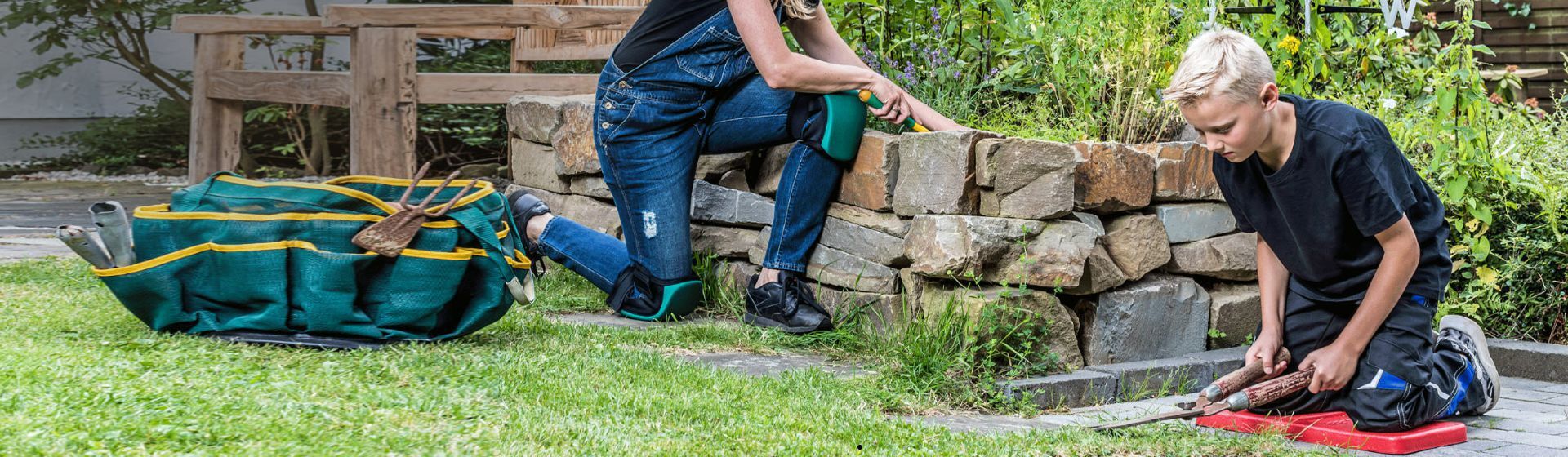 Frau und blonder Junge mit Knieschutz bei der Gartenarbeit Frau und blonder Junge mit Knieschutz bei der Gartenarbeit