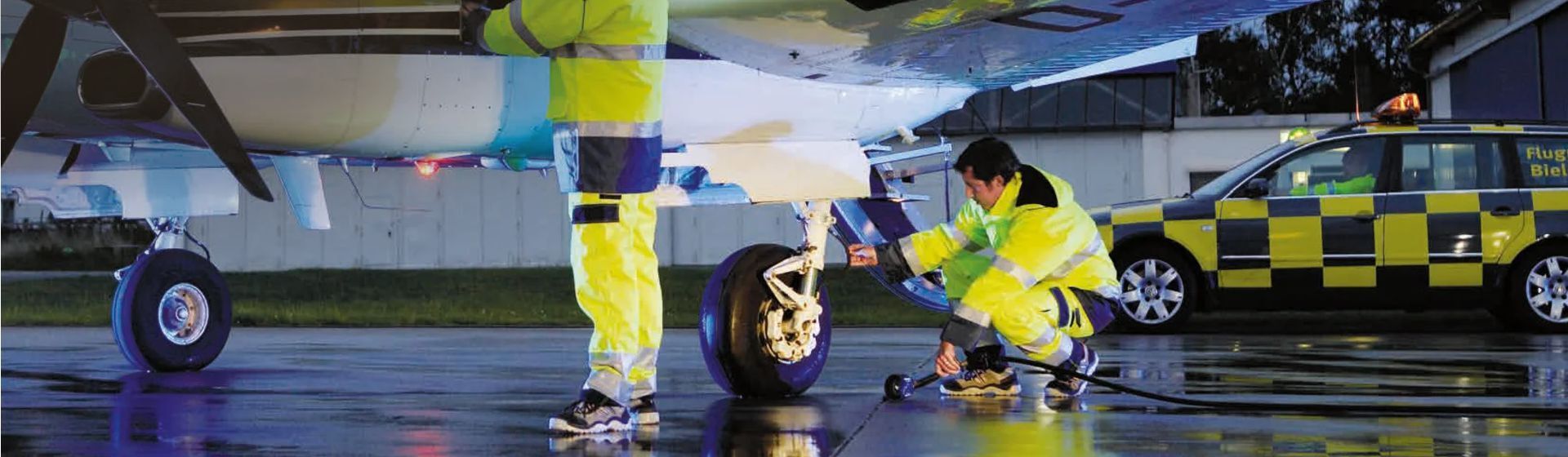 Zwei Flughafen Arbeiter in gelber Warnschutzkleidung Zwei Flughafen Arbeiter in gelber Warnschutzkleidung