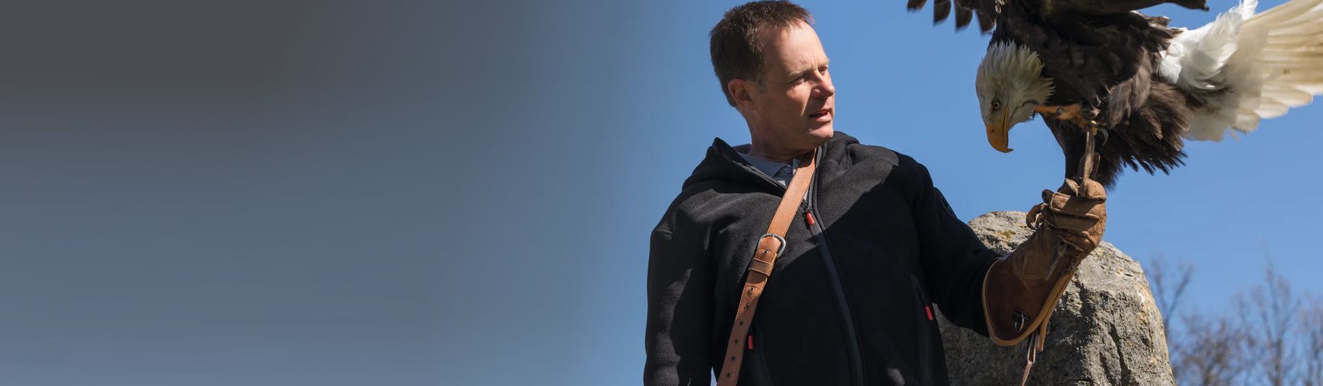 Mann in einer Winterjacke von Planam mit einem Adler auf der Hand Mann in einer Winterjacke von Planam mit einem Adler auf der Hand