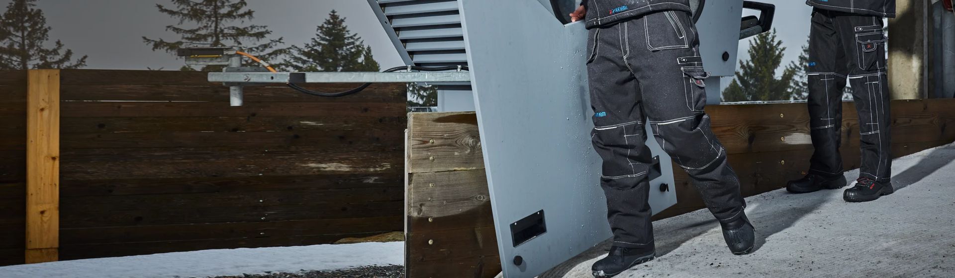 Zwei Männer in schwarzen Winter-Arbeitshosen von Planam Zwei Männer in schwarzen Winter-Arbeitshosen von Planam