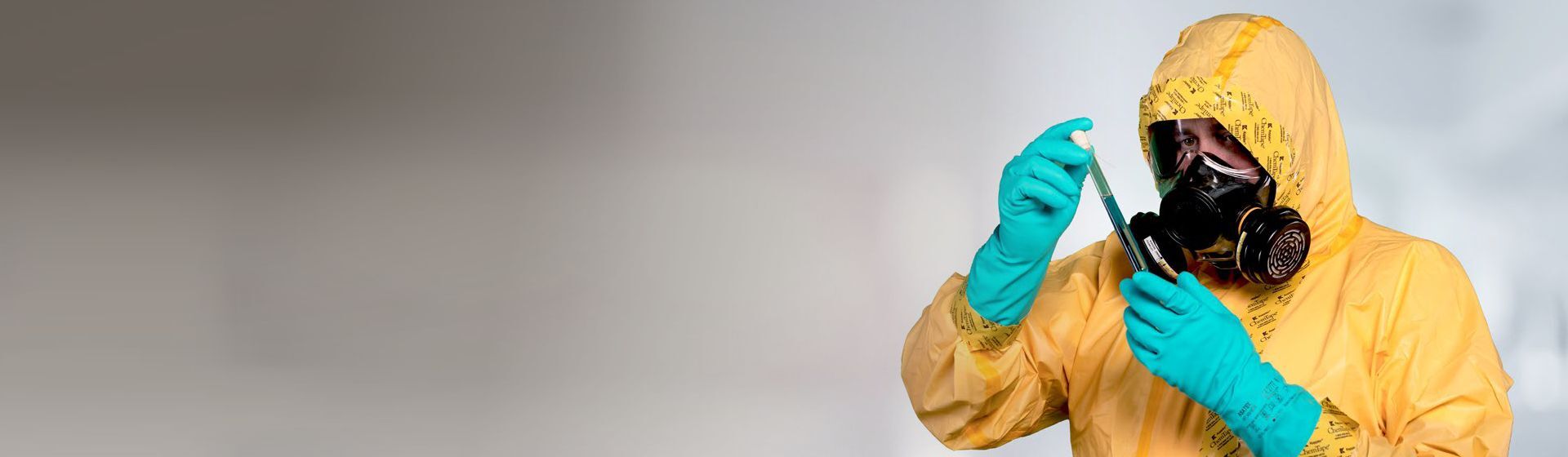 Mann in gelber Einwegschutzkleidung mit Kopfhaube
