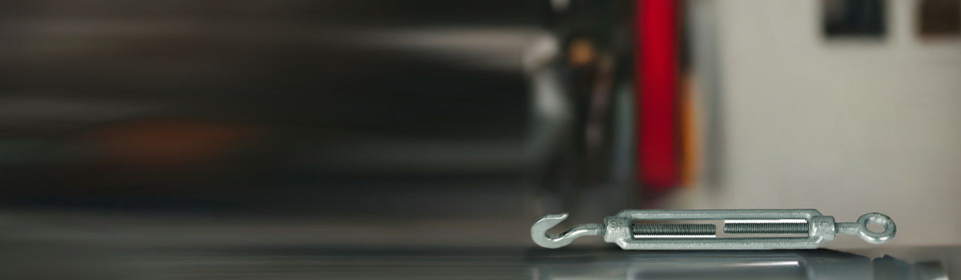 Silberfarbenes Spannschloss auf einer Werkbank liegend Silberfarbenes Spannschloss auf einer Werkbank liegend