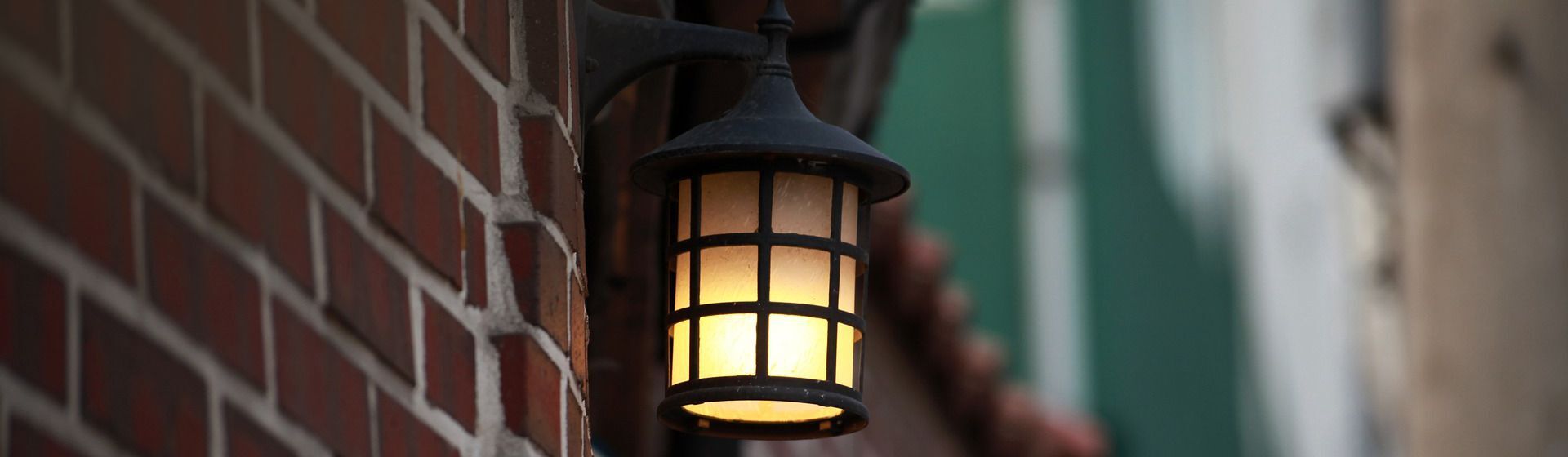 Schwarze Außenleuchte an einer rot-braunen Backsteinwand montiert Schwarze Außenleuchte an einer rot-braunen Backsteinwand montiert