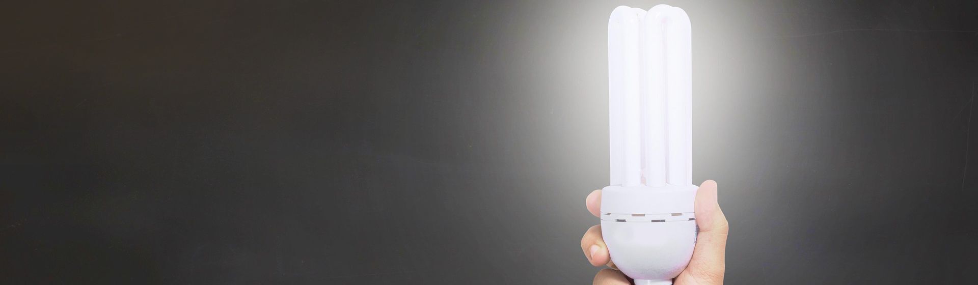 Energiesparlampe vor schwarzem Hintergrund