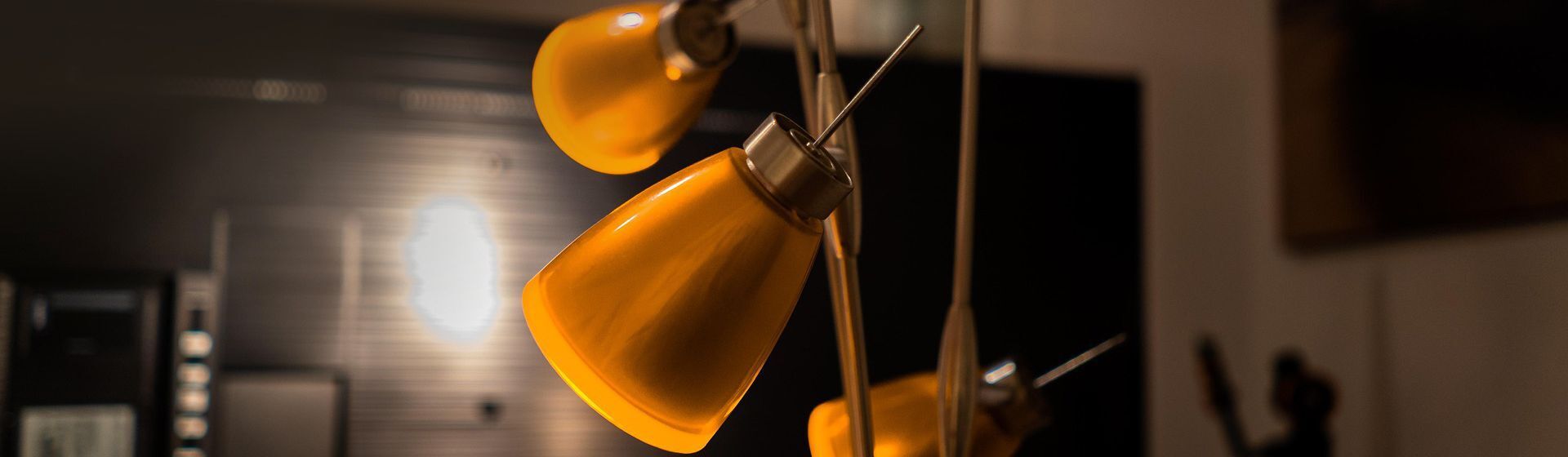 Stehleuchte mit orangefarbenen Lampenschirmen aus Glas in einem Wohnraum