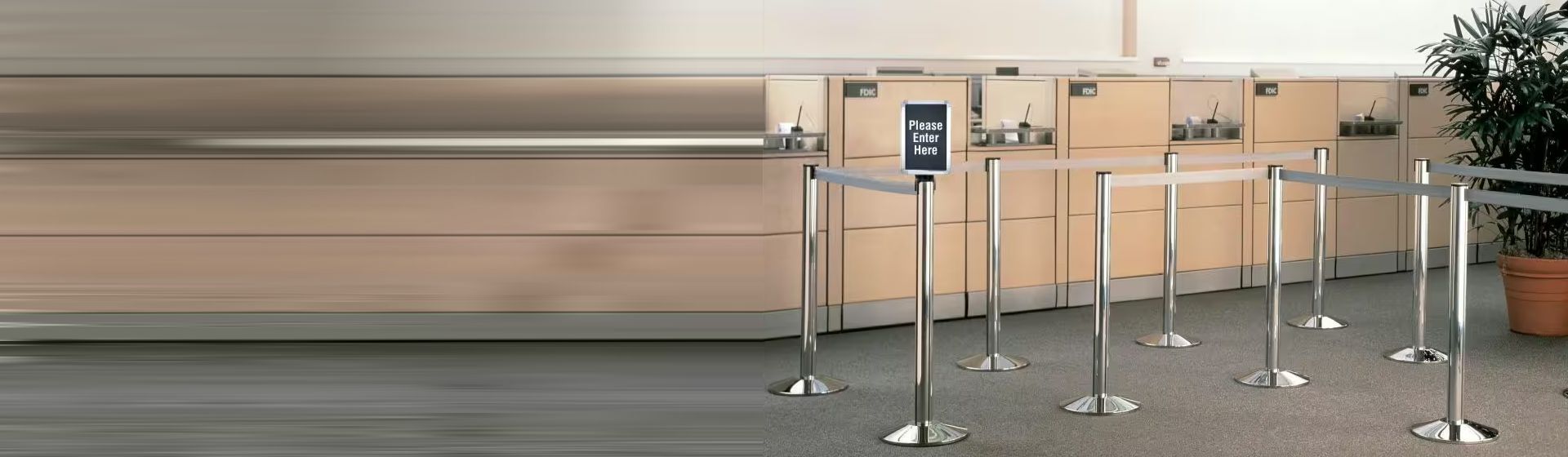 Leitsystem mit Edelstahlpfosten und grauem Band von ViaGuide in einem Wartebereich Leitsystem mit Edelstahlpfosten und grauem Band von ViaGuide in einem Wartebereich