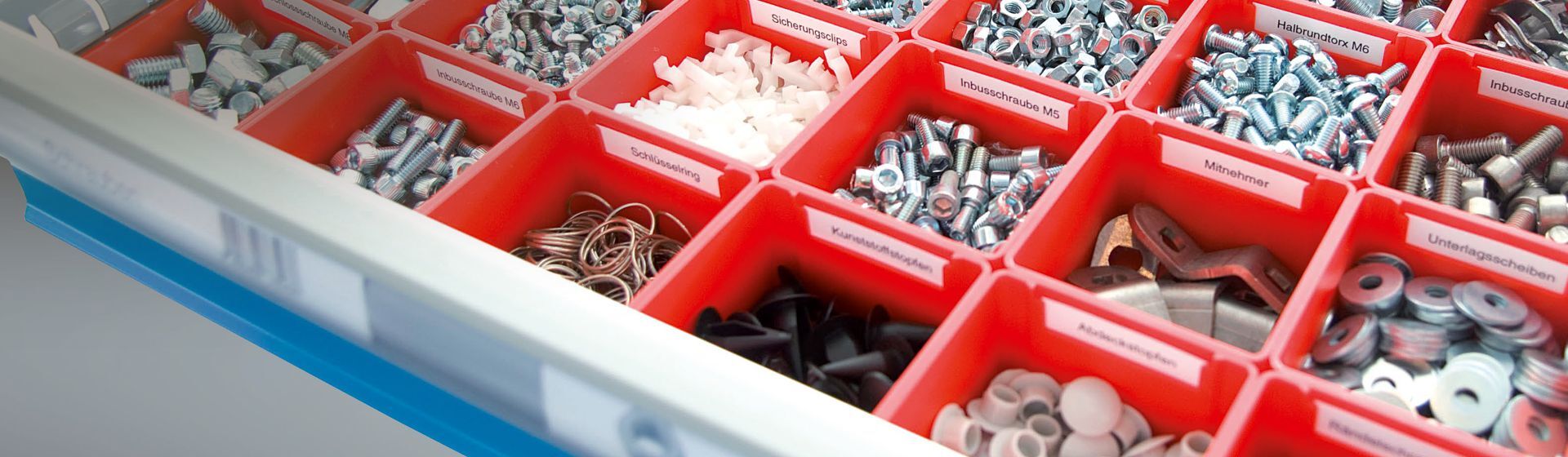 Rote Schubladeneinteilung gefüllt mit Kleinteilen wie Schrauben, Torx und ähnliche Rote Schubladeneinteilung gefüllt mit Kleinteilen wie Schrauben, Torx und ähnliche
