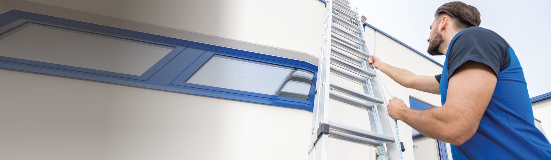 Handwerker bei der Bedienung einer Seilzugleiter Handwerker bei der Bedienung einer Seilzugleiter