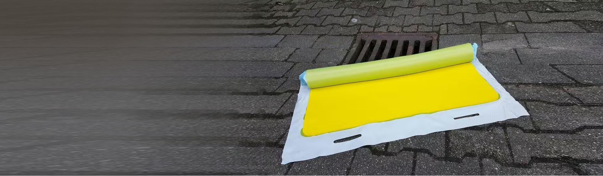 Gelbe Absperrmatte von Schoeller vor einem Gulli Gelbe Absperrmatte von Schoeller vor einem Gulli