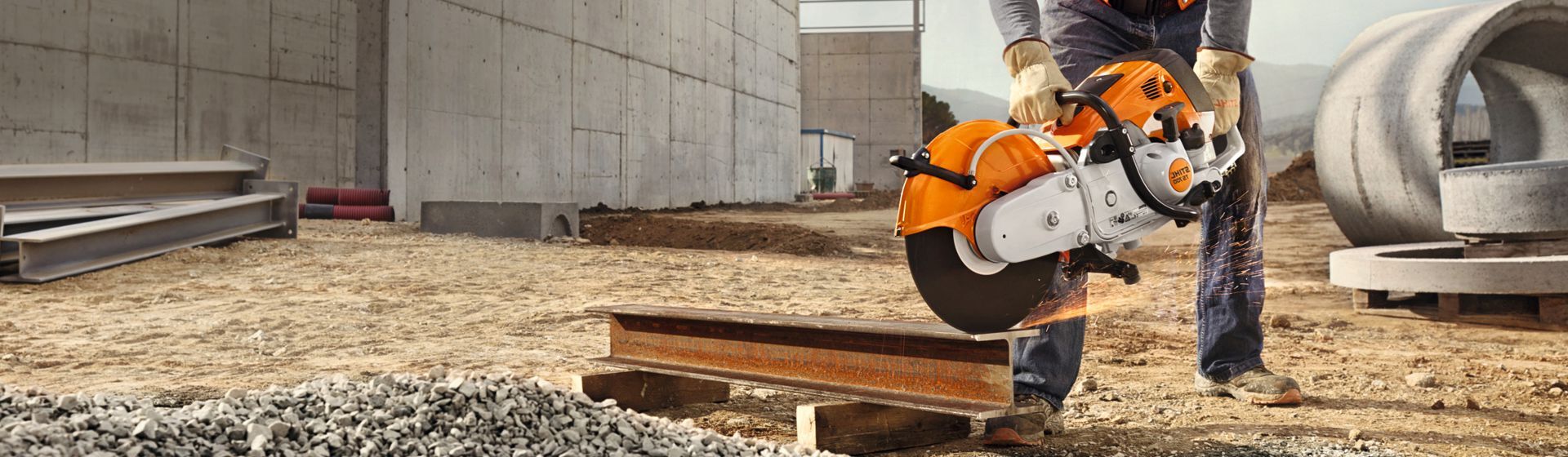Bauarbeiter bearbeitet einen auf dem Boden liegenden Stahlträger mit einem Stihl Trennschleifer Bauarbeiter bearbeitet einen auf dem Boden liegenden Stahlträger mit einem Stihl Trennschleifer