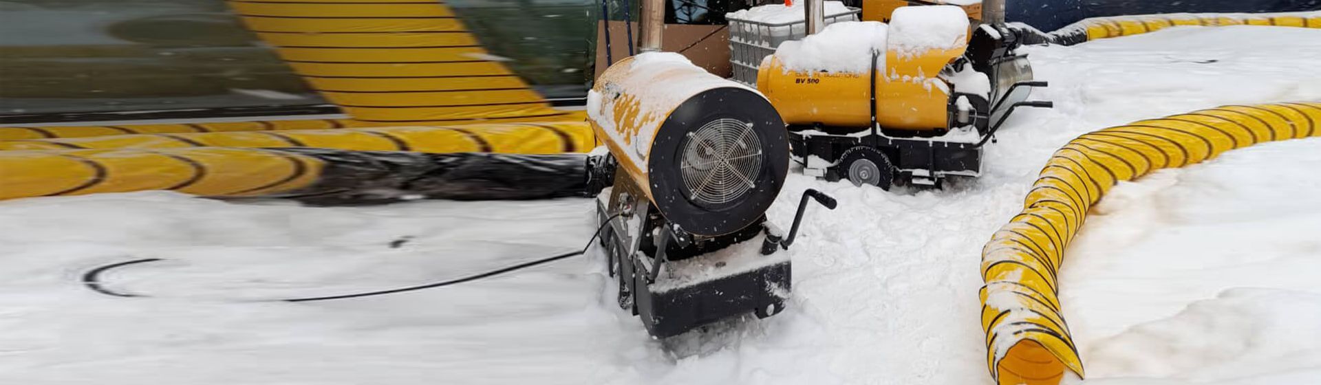 Master Heizgeräte und Abluftschläuche im Schnee vor einem Gebäude Master Heizgeräte und Abluftschläuche im Schnee vor einem Gebäude