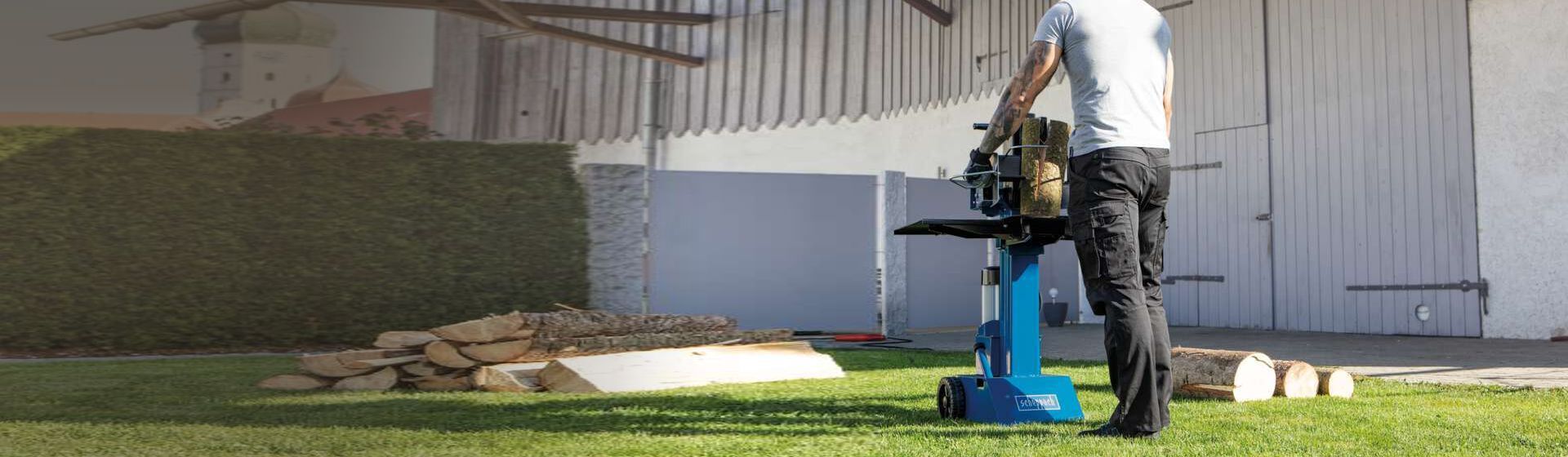 Mann spaltet Brennholz in einem Garten mit einem Scheppach Holzspalter Mann spaltet Brennholz in einem Garten mit einem Scheppach Holzspalter