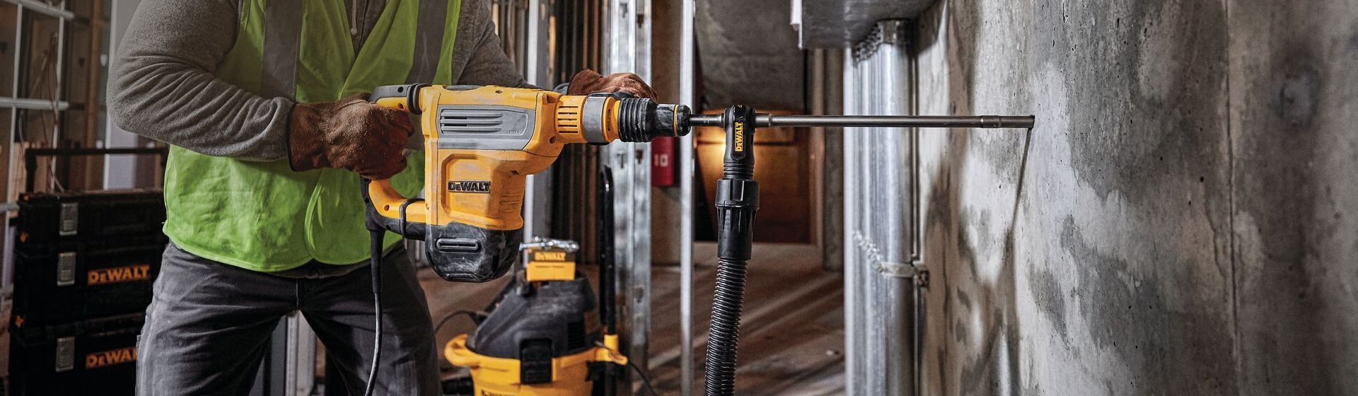 Bauarbeiter bearbeitet eine Betonwand mit einem Dewalt Meißelhammer Bauarbeiter bearbeitet eine Betonwand mit einem Dewalt Meißelhammer
