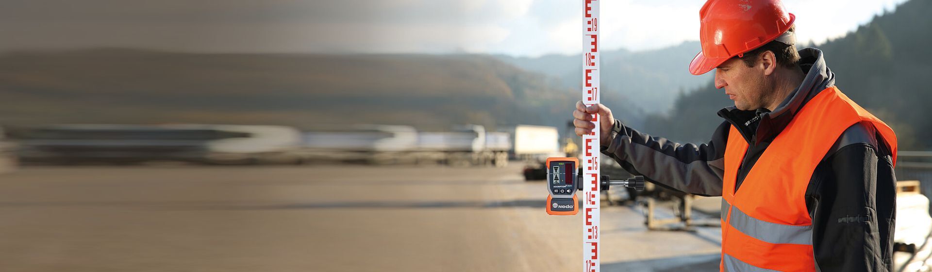 Straßenbauarbeiter mit einer Nedo Nivellierlatten aus Holz Straßenbauarbeiter mit einer Nedo Nivellierlatten aus Holz