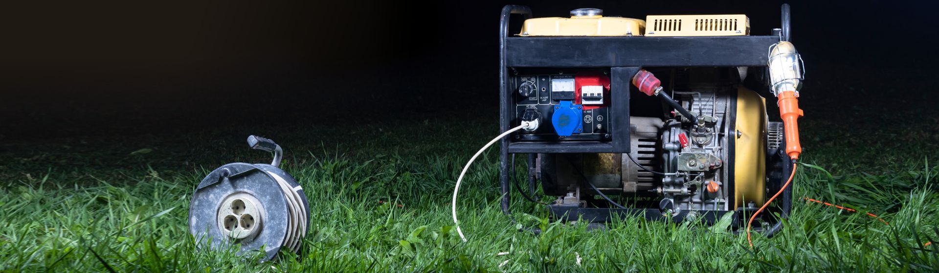 Stromerzeuger & Kabeltrommel auf einer Rasenfläche stehend Stromerzeuger & Kabeltrommel auf einer Rasenfläche stehend