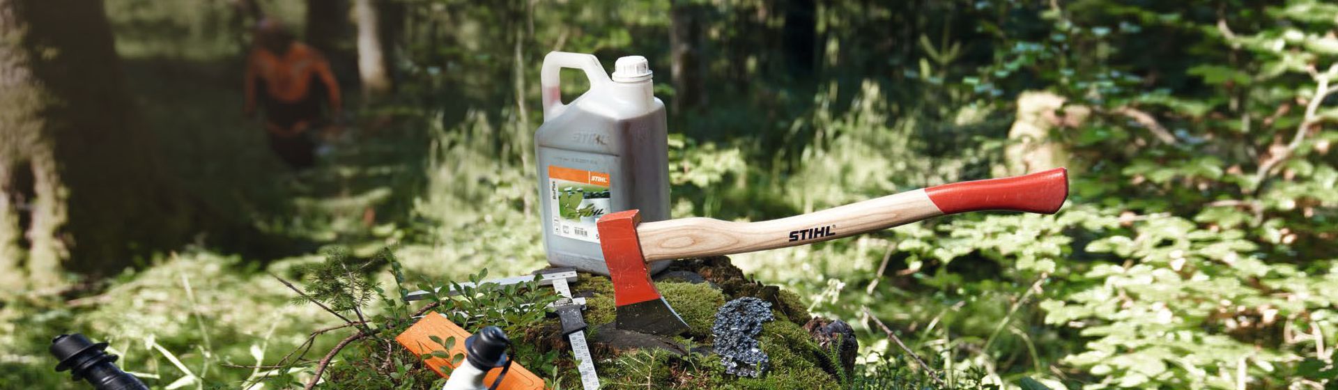 Stihl Axt in einem bemoosten Baumstumpf steckend im Wald Stihl Axt in einem bemoosten Baumstumpf steckend im Wald