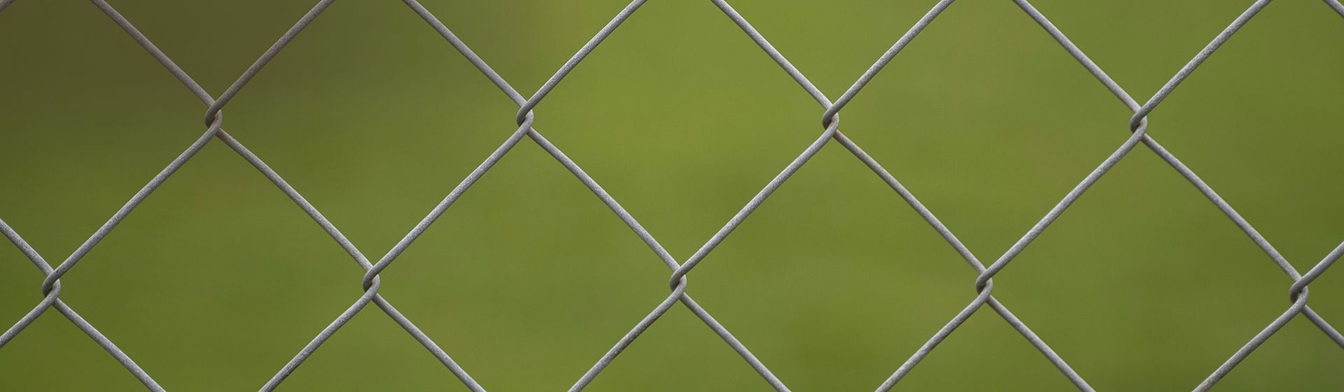 Grauer Maschendrahtzaun in Nahaufnahme Grauer Maschendrahtzaun in Nahaufnahme