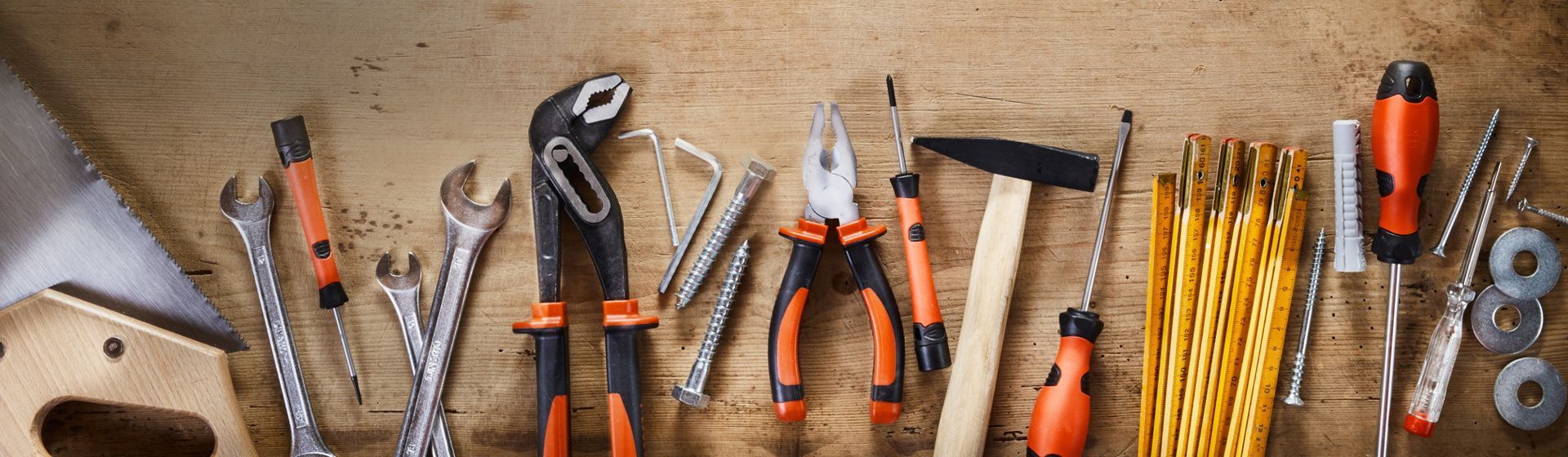 Verschiedene Handwerkzeuge auf einer Werkbankplatte aus Holz liegend Verschiedene Handwerkzeuge auf einer Werkbankplatte aus Holz liegend