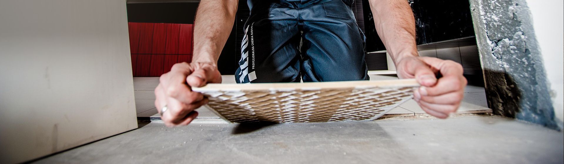 Handwerker verlegt eine Bodenfliese Handwerker verlegt eine Bodenfliese