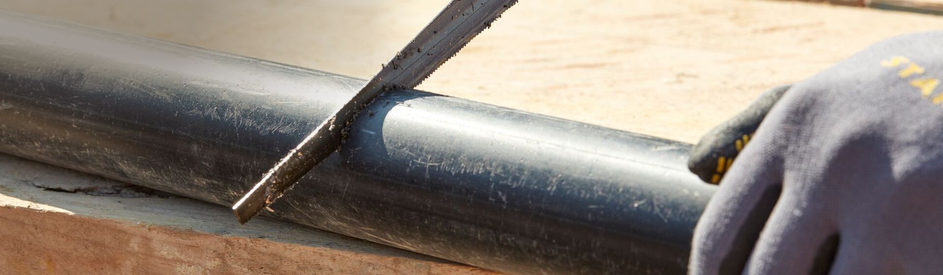 Stanley Dämmstoffmesser beim Durchtrennen eines schwarzen Rohrs Stanley Dämmstoffmesser beim Durchtrennen eines schwarzen Rohrs