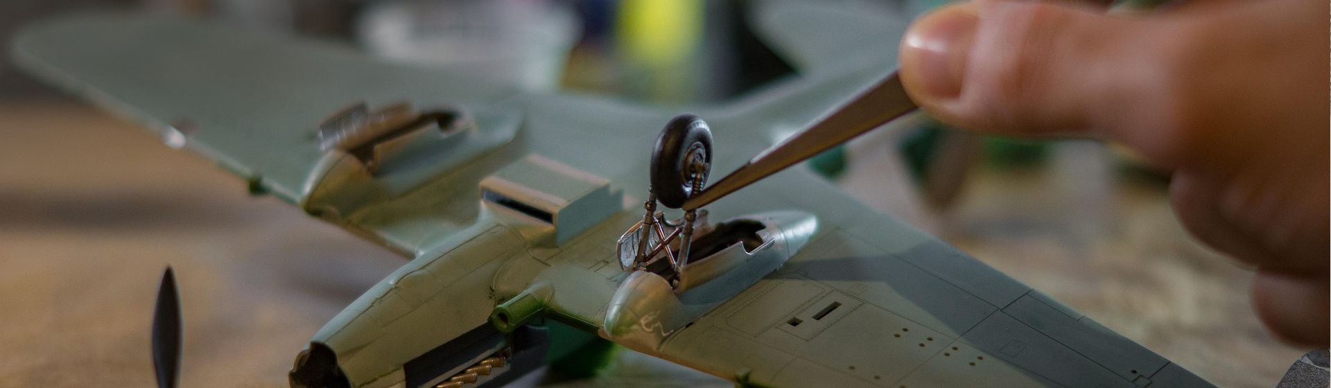 Befestigen eines Fahrwerks an einem auf dem Rücken liegenden Modellflugzeugs mit Hilfe einer Pinzette Befestigen eines Fahrwerks an einem auf dem Rücken liegenden Modellflugzeugs mit Hilfe einer Pinzette
