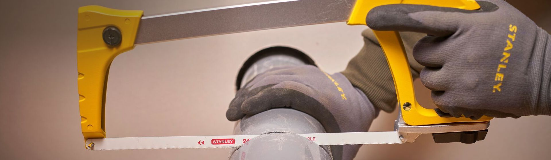 Bügelsäge von Stanley beim Sägen eines Rohrs Bügelsäge von Stanley beim Sägen eines Rohrs