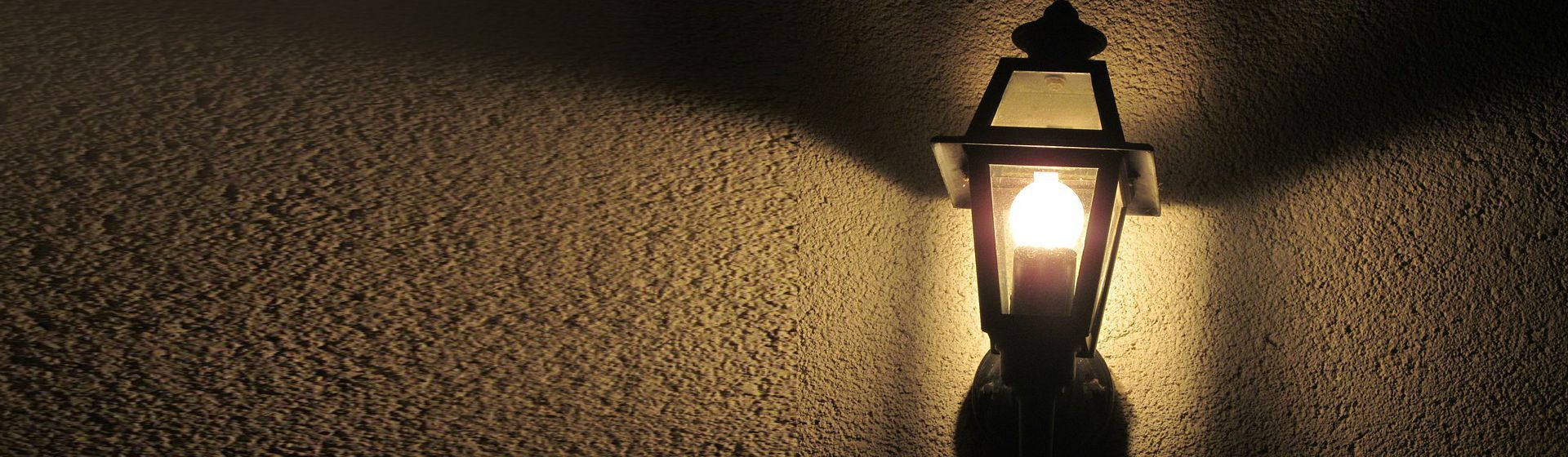 Schwarze Außenleuchte in Laternendesign montiert an einer Hauswand