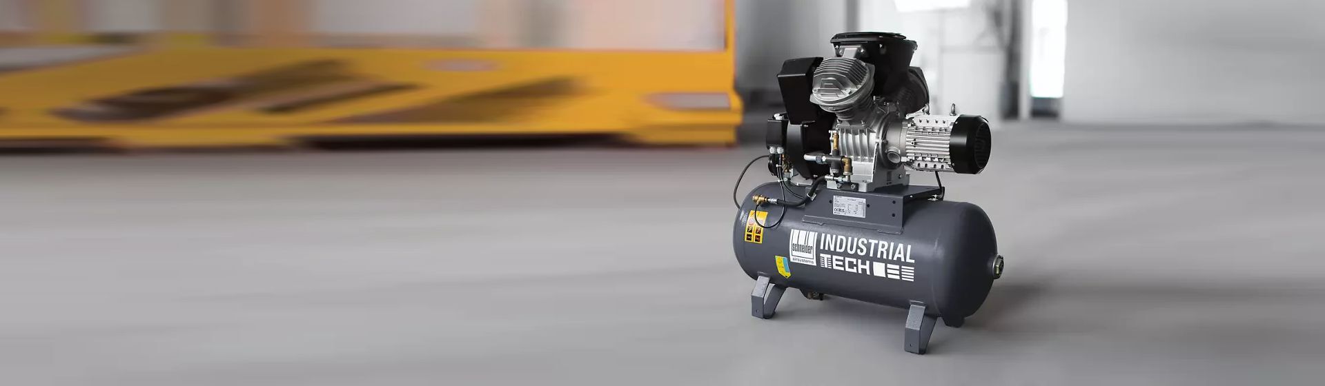 Schneider Druckluft Kompressor in einer Industriehalle stehend Schneider Druckluft Kompressor in einer Industriehalle stehend