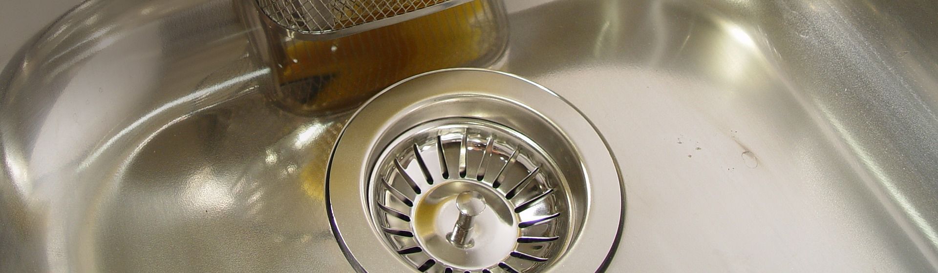 Silberfarbener Siebeinsatz in einem Spülbecken Silberfarbener Siebeinsatz in einem Spülbecken