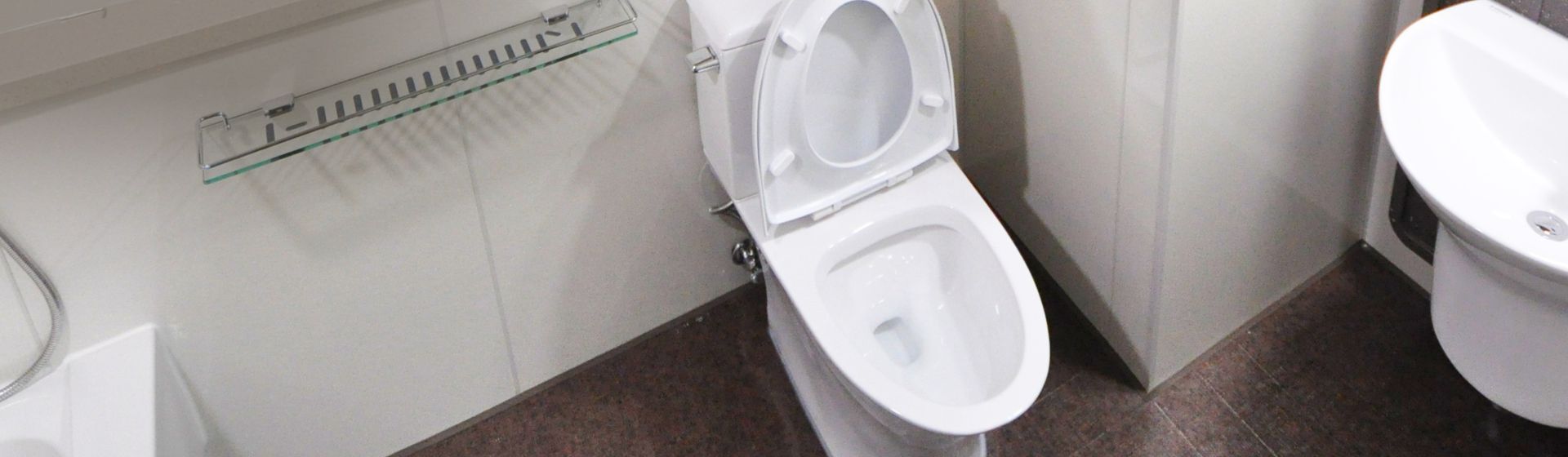 Weiße Toilette mit offnem Deckel in einem Badezimmer